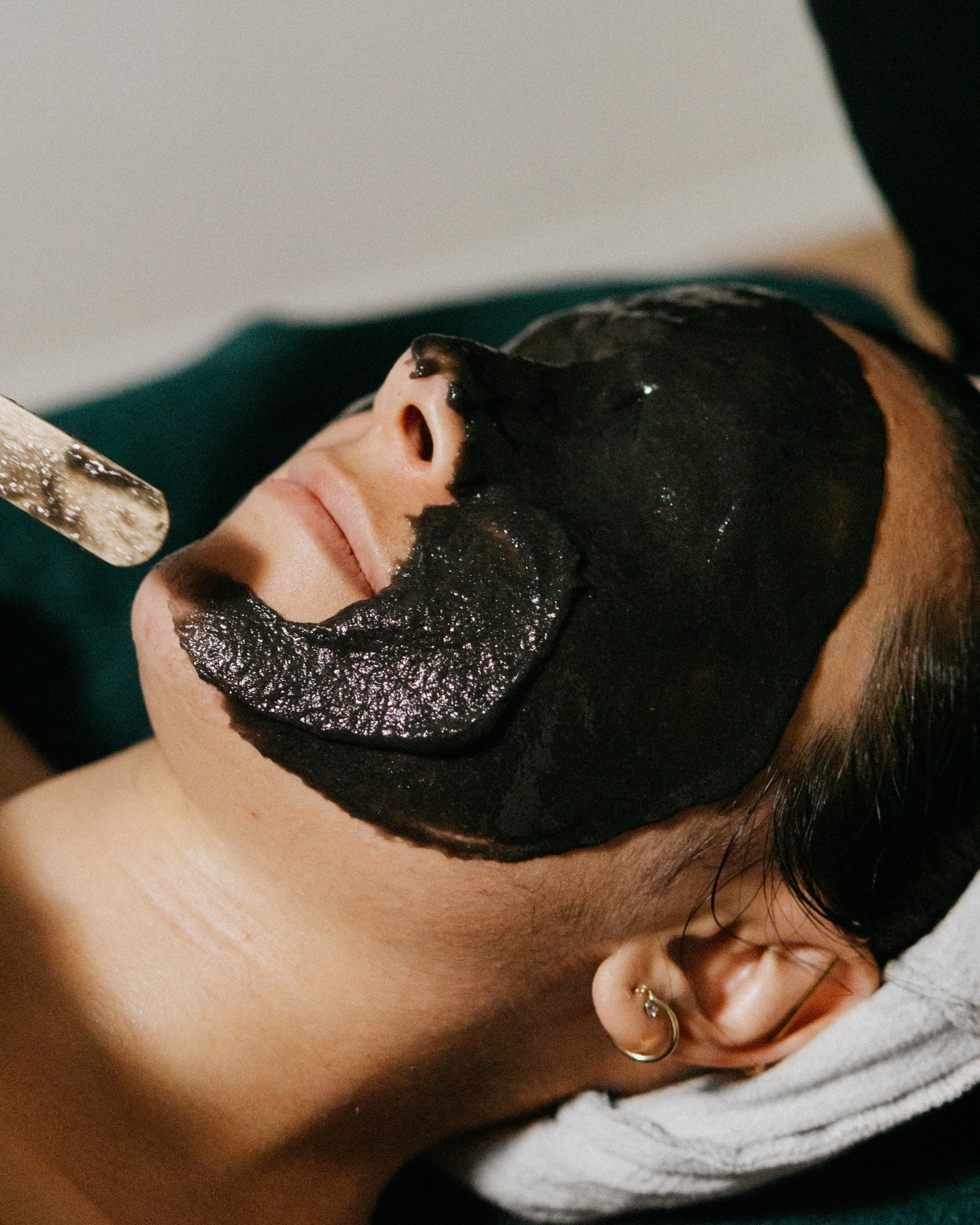 Overhead view of a charcoal facial mask treatment at Succulent Skin Studio